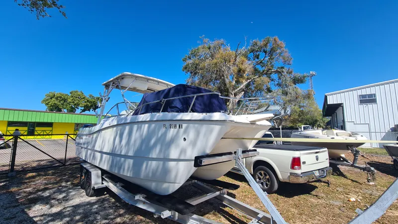 Slide: The Image of 2009 World Cat 250 DC boat on trailer, parked outdoors under clear blue sky. - 5