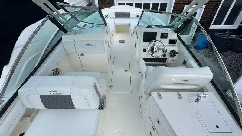 Slide: The Image of 2025 Cobia 240 Dual Console boat interior with white seating and modern dashboard. - 17