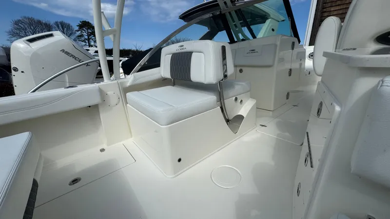 Slide: The Image of 2025 Cobia 240 Dual Console boat interior with white seating and modern design. - 21