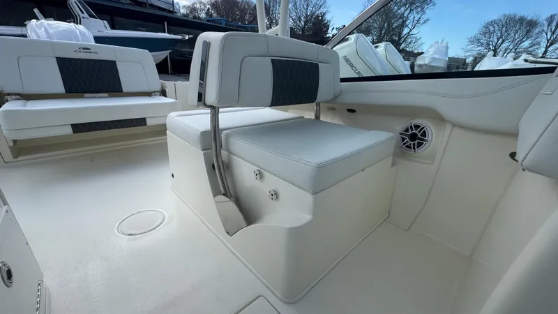 Slide: The Image of 2025 Cobia 240 Dual Console interior seating with modern design and speaker system. - 22