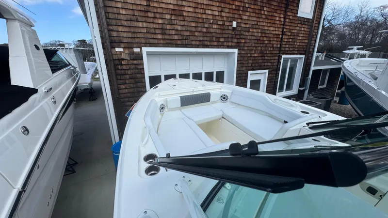 Slide: The Image of 2025 Cobia 240 Dual Console boat docked near a wooden building. - 29