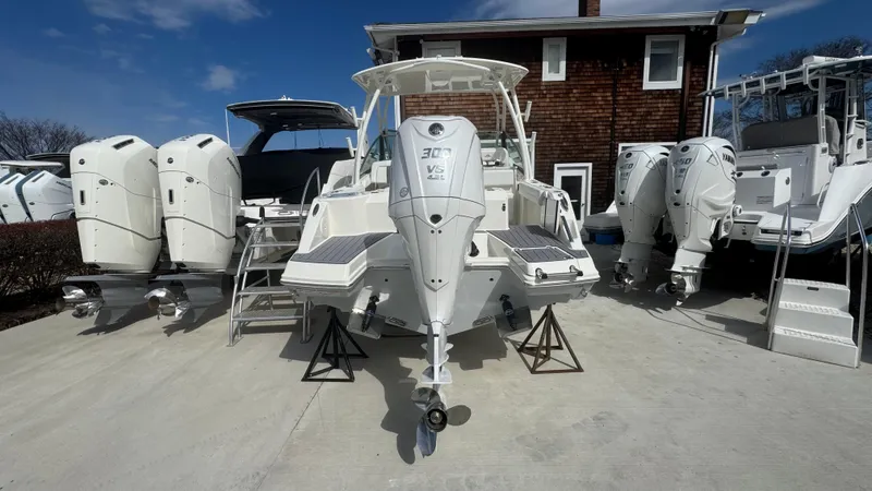 Slide: The Image of 2025 Cobia 240 Dual Console boat displayed outdoors with multiple engines. - 3