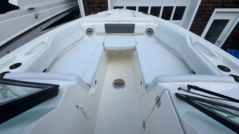 Slide: The Image of 2025 Cobia 240 Dual Console boat interior with white seating and speakers. - 30