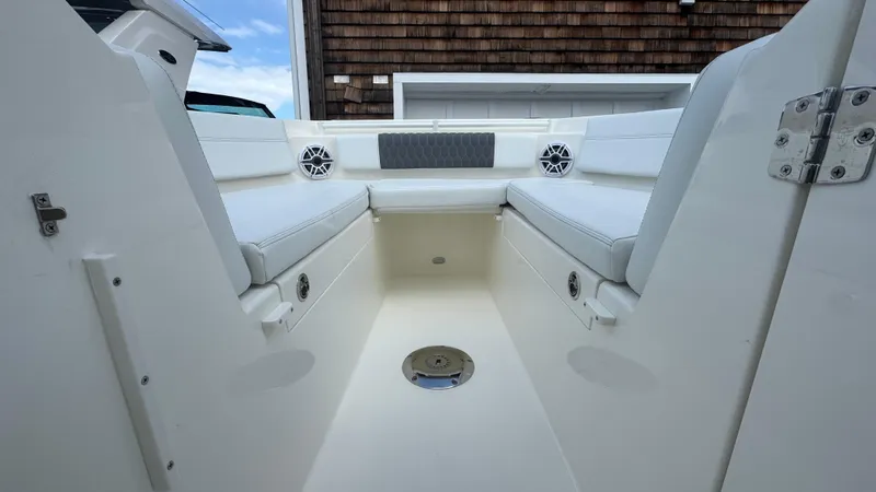 Slide: The Image of 2025 Cobia 240 Dual Console boat interior with white seating and speakers. - 31