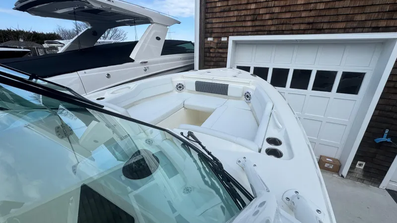 Slide: The Image of 2025 Cobia 240 Dual Console boat docked near a garage. - 32