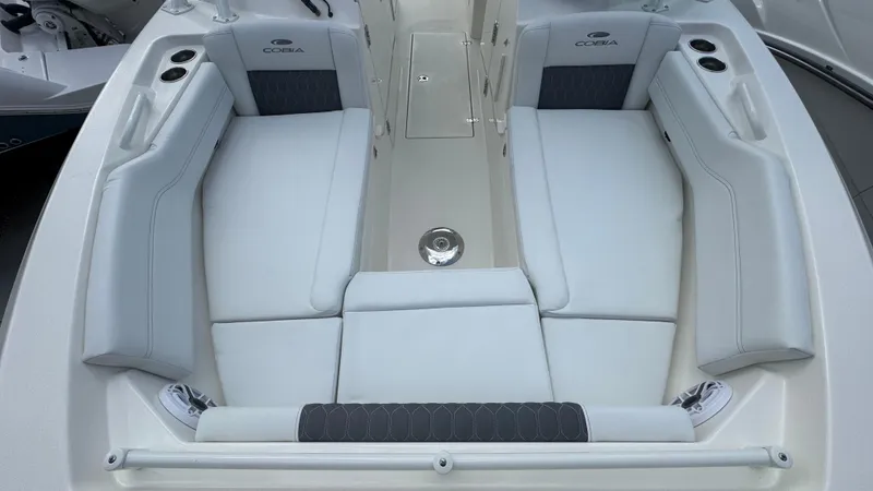 Slide: The Image of 2025 Cobia 240 Dual Console boat interior with white seating and cup holders. - 33