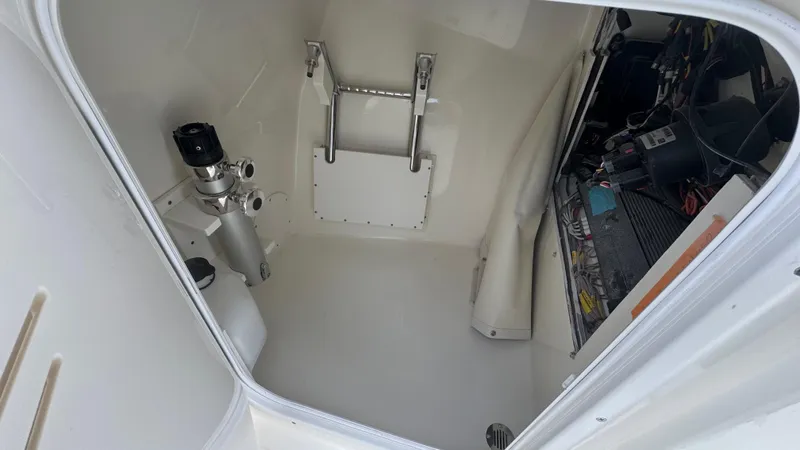 Slide: The Image of 2025 Cobia 240 Dual Console boat interior storage compartment with equipment and wiring. - 36