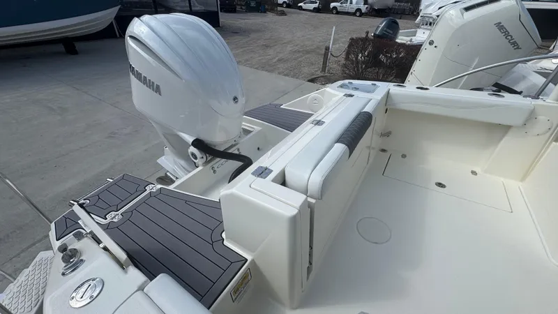 Slide: The Image of 2025 Cobia 240 Dual Console boat with Yamaha outboard engine, featuring spacious deck and seating. - 7
