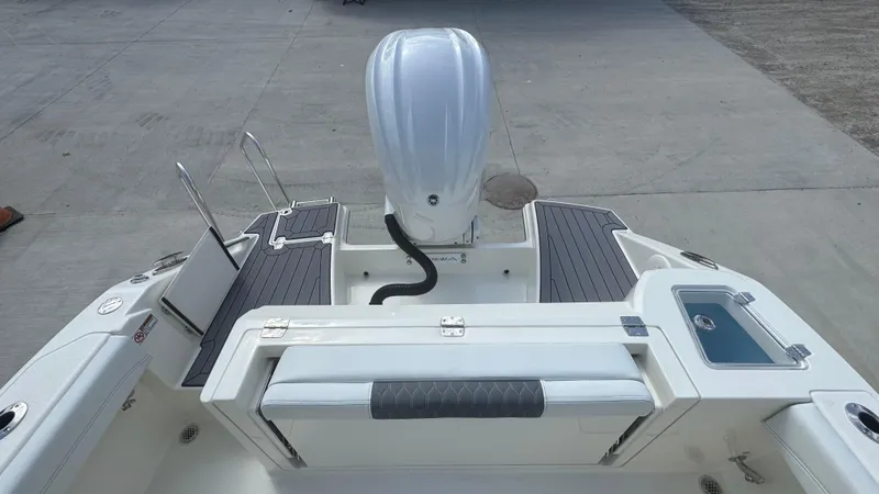 Slide: The Image of 2025 Cobia 240 Dual Console boat, rear view with motor and seating area. - 8