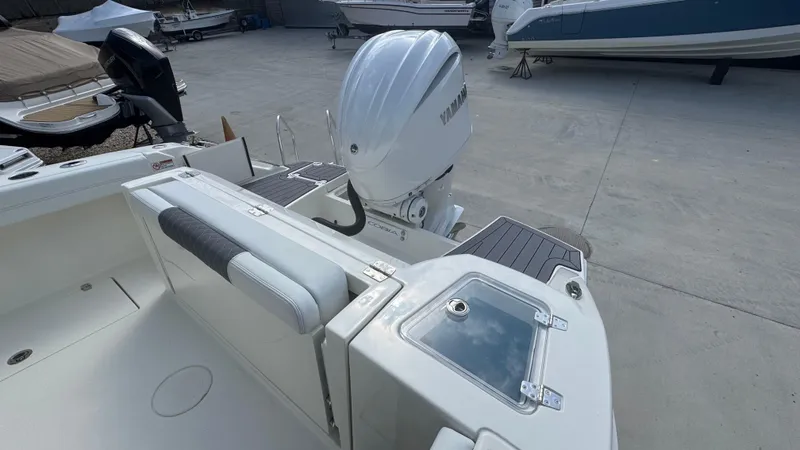 Slide: The Image of 2025 Cobia 240 Dual Console boat with Yamaha outboard motor, docked on concrete. - 9
