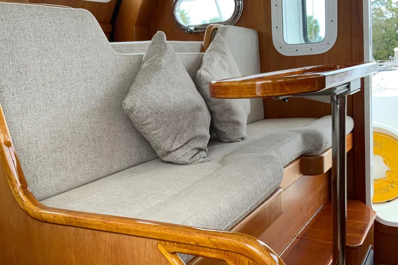 Slide: The Image of Interior of 2001 Nordhavn 40 yacht with cushioned seating and wooden accents. - 17