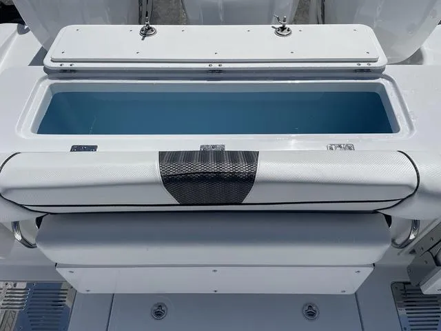 Slide: The Image of 2023 Wellcraft 352 Fisherman boat storage compartment with open lid, showcasing interior space. - 13