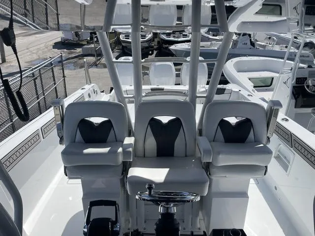 Slide: The Image of 2023 Wellcraft 352 Fisherman boat cockpit with three cushioned seats and steering wheel. - 16