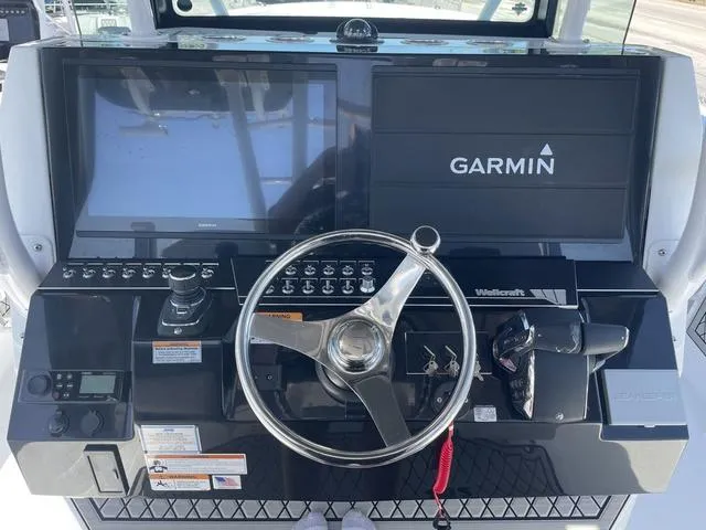 Slide: The Image of 2023 Wellcraft 352 Fisherman helm with Garmin navigation system and steering wheel. - 17
