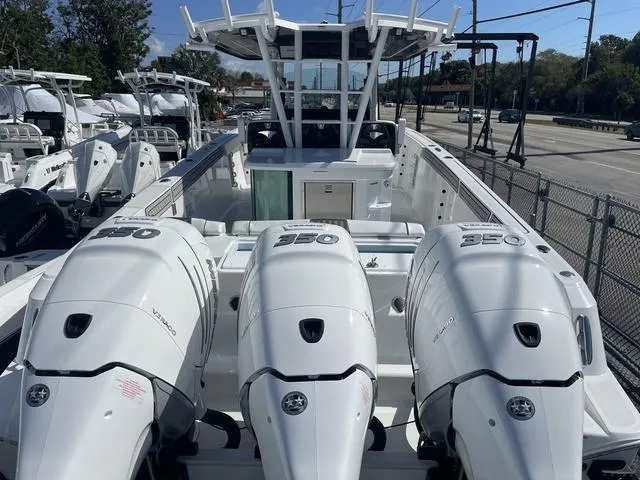 Slide: The Image of 2023 Wellcraft 352 Fisherman boat with triple 350 horsepower engines, docked outdoors. - 2