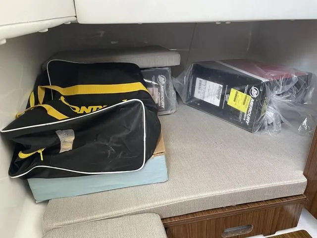 Slide: The Image of 2023 Wellcraft 352 Fisherman cabin storage with bags and boxes on cushioned seating. - 34