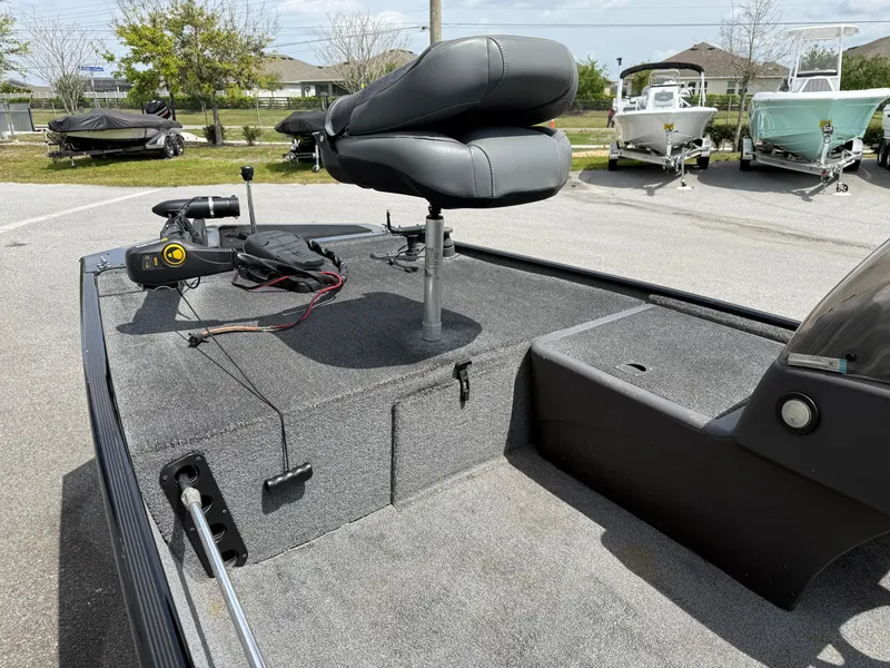 Slide: The Image of 2020 Bass Tracker Classic XL boat interior with seating and equipment, parked outdoors. - 9