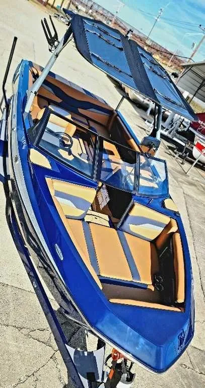 Slide: The Image of 2024 Axis Core Series T235 boat with blue and tan interior, docked outdoors. - 3