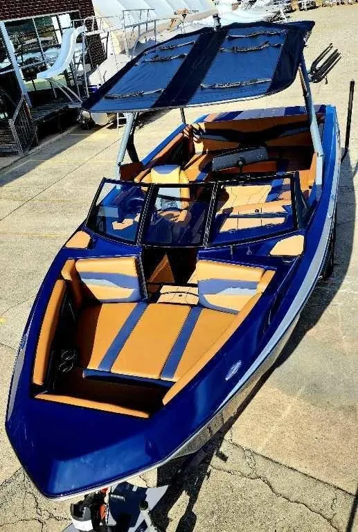 Slide: The Image of 2024 Axis Core Series T235 boat with blue and orange interior, docked outdoors. - 4