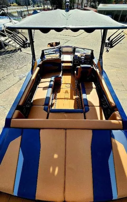 Slide: The Image of 2024 Axis Core Series T235 boat with blue and orange interior, docked under a canopy. - 7