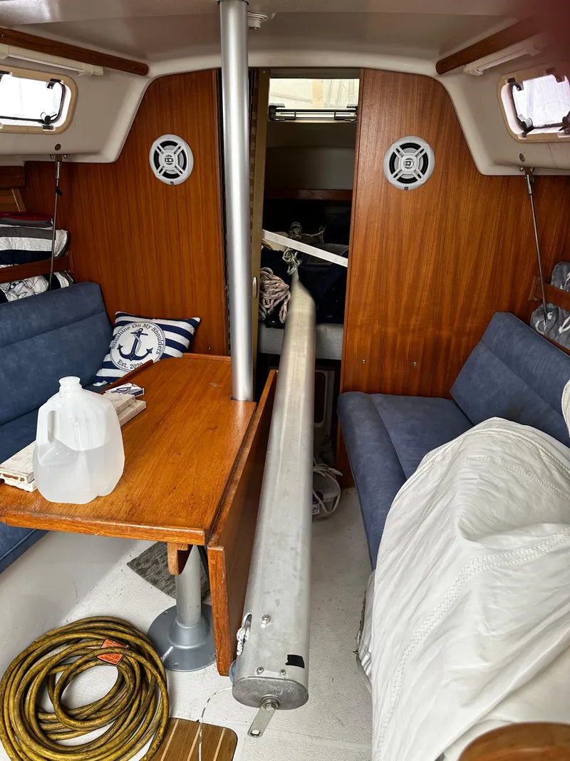 Slide: The Image of Interior of a 1997 Catalina 28 MkII sailboat with wooden paneling and blue seating. - 13