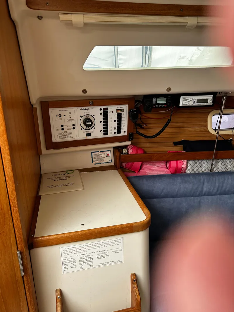 Slide: The Image of Interior of a 1997 Catalina 28 MkII sailboat showing control panel and seating area. - 14