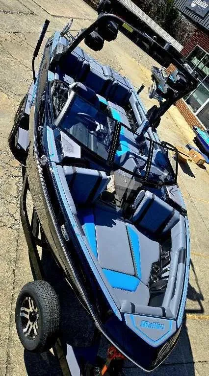 Slide: The Image of 2025 Malibu Wakesetter 25 LSV boat with sleek design and blue accents on a trailer. - 3