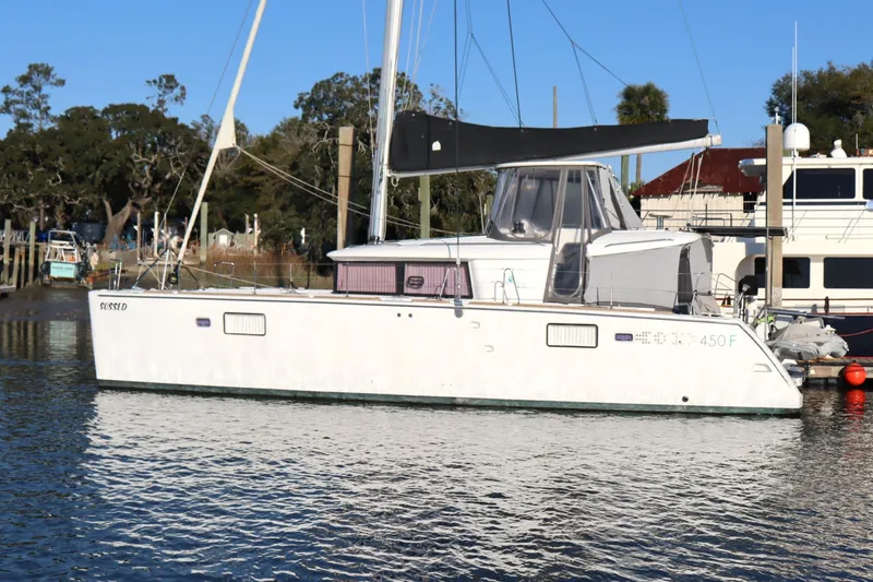 Slide: The Image of 2017 Lagoon 450 F catamaran docked in a marina, under clear blue sky. - 0