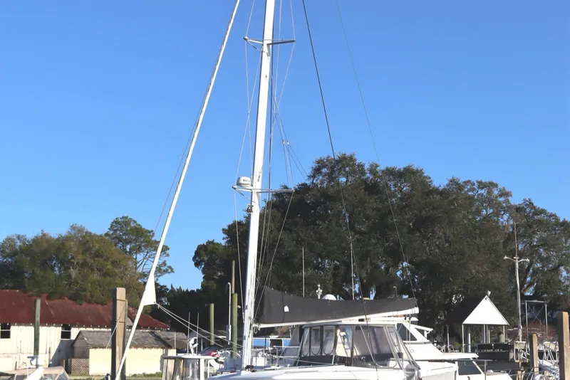 Slide: The Image of 2017 Lagoon 450 F catamaran docked, surrounded by trees and clear blue sky. - 1