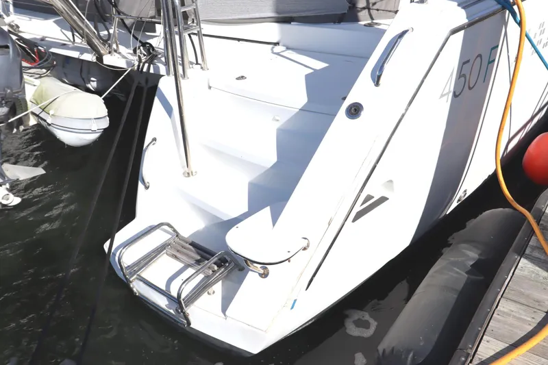 Slide: The Image of 2017 Lagoon 450 F yacht stern with boarding ladder and docked at marina. - 10