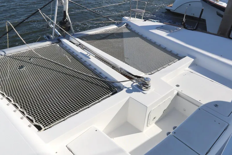 Slide: The Image of 2017 Lagoon 450 F catamaran deck with netting and ropes on the water. - 11