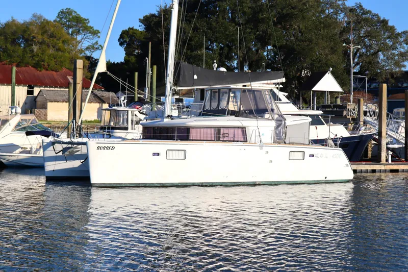 Slide: The Image of 2017 Lagoon 450 F catamaran docked at a marina, surrounded by other boats. - 2