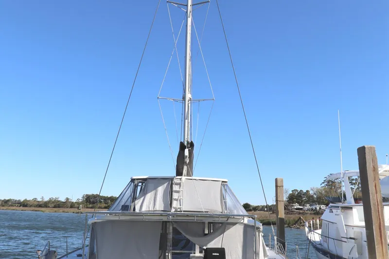 Slide: The Image of 2017 Lagoon 450 F catamaran docked, featuring a tall mast and clear blue sky. - 3