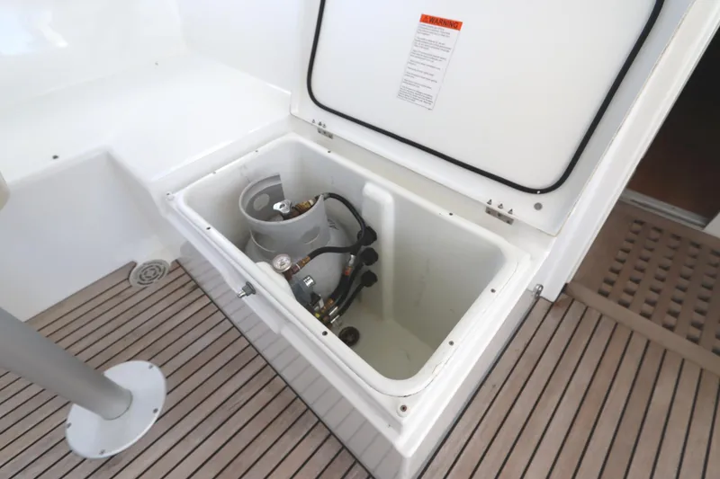 Slide: The Image of Storage compartment on 2017 Lagoon 450 F yacht with gas cylinder and wooden deck. - 37