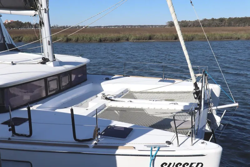 Slide: The Image of 2017 Lagoon 450 F catamaran on calm water, featuring spacious deck and netting. - 7