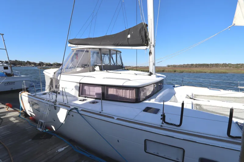 Slide: The Image of 2017 Lagoon 450 F catamaran docked by the water on a clear day. - 8