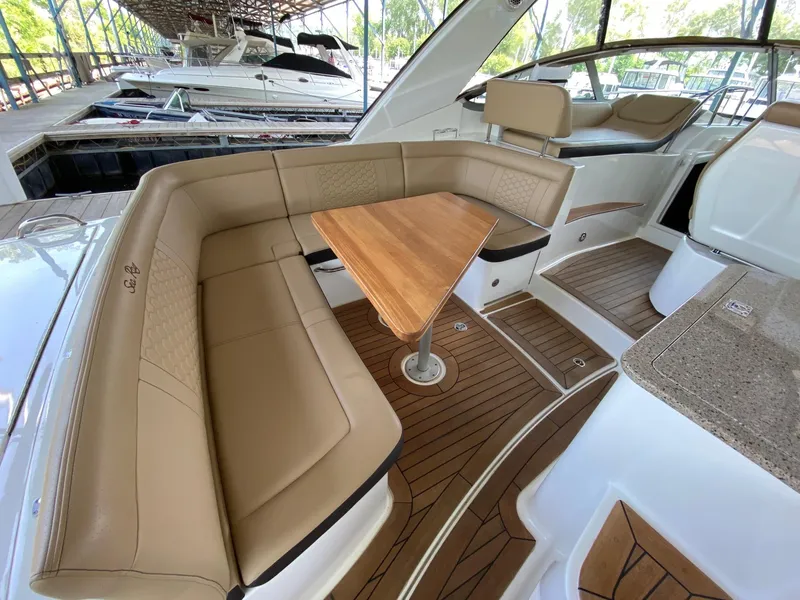 Slide: The Image of Luxurious 2018 Sea Ray Sundancer 350 yacht interior with tan seating and wooden table. - 12