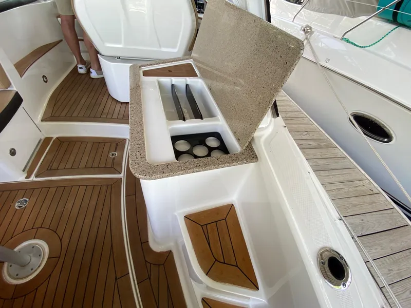 Slide: The Image of 2018 Sea Ray Sundancer 350 boat interior with open storage compartment and wooden flooring. - 14