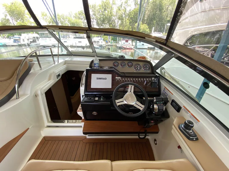 Slide: The Image of 2018 Sea Ray Sundancer 350 helm with Simrad display, steering wheel, and control panel. - 18