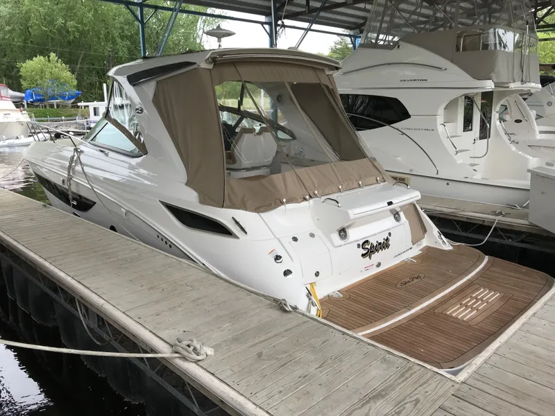 Slide: The Image of 2018 Sea Ray Sundancer 350 docked, featuring sleek design and covered cockpit. - 2