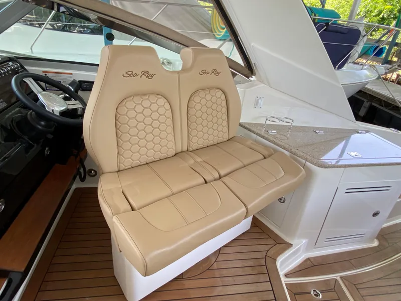 Slide: The Image of 2018 Sea Ray Sundancer 350 interior with beige leather seats and wooden flooring. - 23