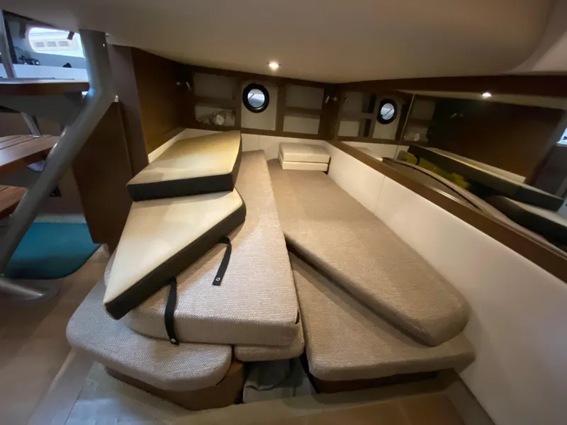 Slide: The Image of 2018 Sea Ray Sundancer 350 cabin interior with stacked cushions and porthole windows. - 39