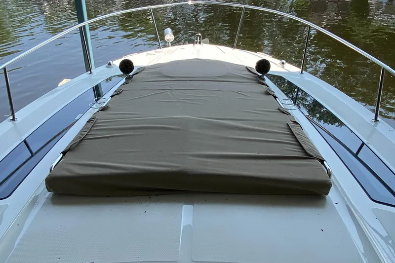 Slide: The Image of 2018 Sea Ray Sundancer 350 boat deck with cover, docked on calm water. - 46