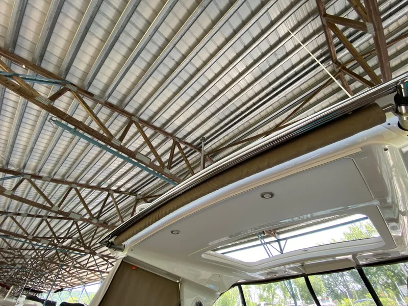 Slide: The Image of 2018 Sea Ray Sundancer 350 under a metal roof, showcasing its sleek design. - 49