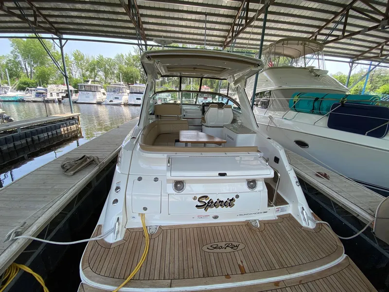 Slide: The Image of 2018 Sea Ray Sundancer 350 docked in marina, rear view with covered seating area. - 6