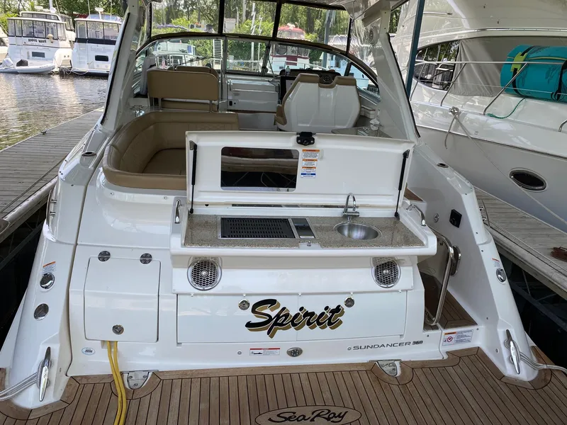 Slide: The Image of 2018 Sea Ray Sundancer 350 yacht with outdoor kitchenette and seating area at a marina. - 8