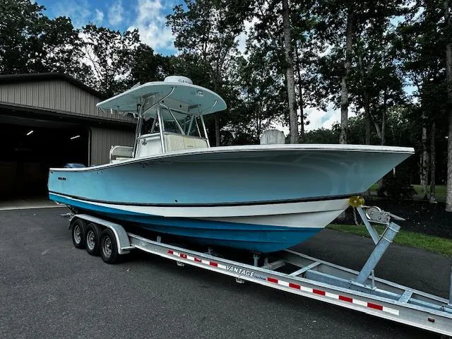 The Image of 2008 Regulator 29 Forward Seating boat on trailer, parked outdoors near a garage. - 0