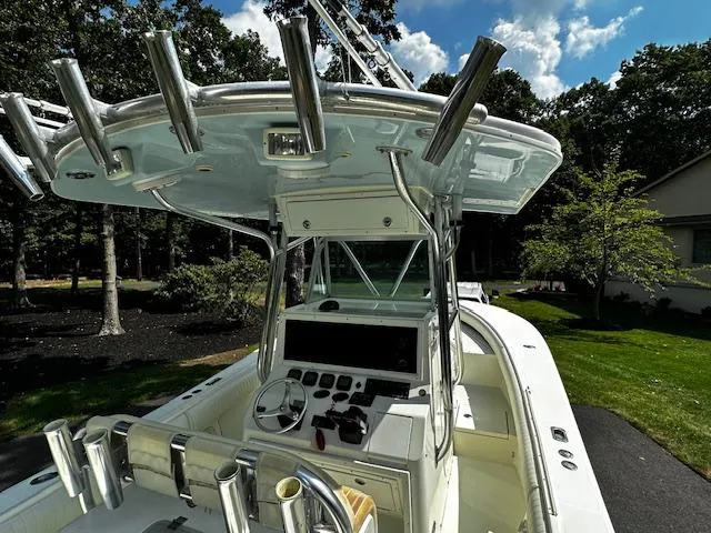 Slide: The Image of 2008 Regulator 29 Forward Seating boat with helm and rod holders, set outdoors. - 16