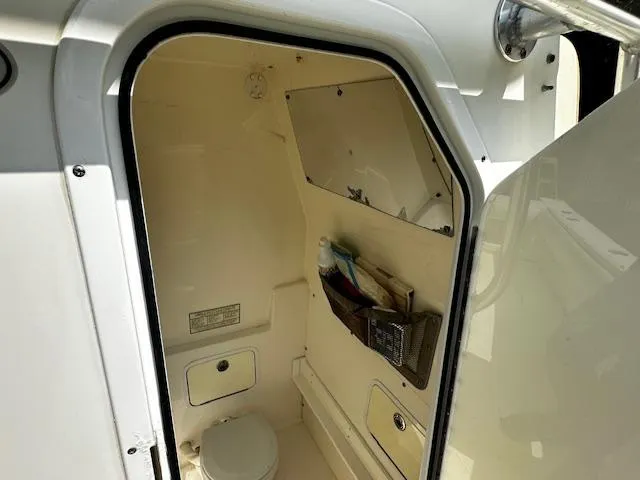 Slide: The Image of Interior of a 2008 Regulator 29 Forward Seating boat, featuring a compact restroom. - 17