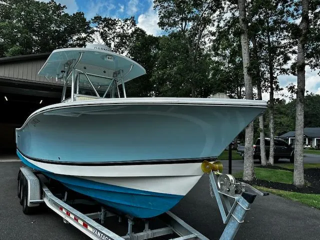 Slide: The Image of 2008 Regulator 29 Forward Seating boat on trailer, parked outdoors near trees. - 2